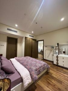1 dormitorio con cama grande y luz en Luxury Apartment with Part Lake View, en Sharjah