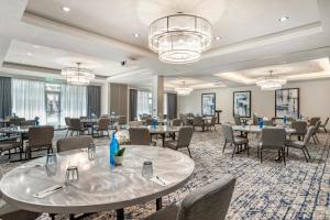 a dining room with tables and chairs and chandeliers at Cambria Hotel Austin Uptown near the Domain in Austin