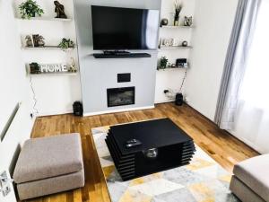 a living room with a flat screen tv on a wall at The Navarone Blue Orchid Flat in London