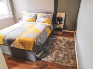 a bedroom with a bed with a blanket and a rug at The Navarone Blue Orchid Flat in London