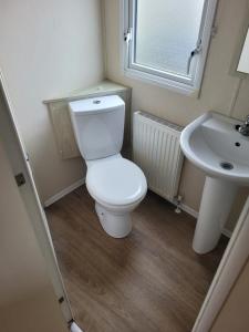 a bathroom with a white toilet and a sink at Point Clear 4 bed Static Caravan in Saint Osyth