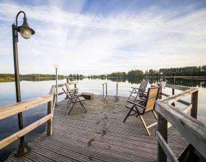 a dock with chairs and a light on the water at Herttua Hotel and Spa in Kerimäki