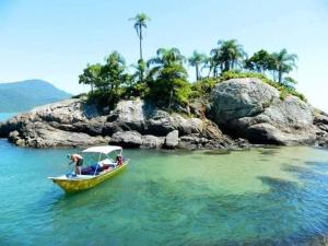 a group of people on a boat in the water at Tá em Casa Peruíbe in Peruíbe