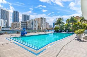 a swimming pool with a city skyline in the background at Spacious VIP Penthouse with Ocean & Intracoastal Views, Private Entry, Resort Amenities in Hallandale Beach