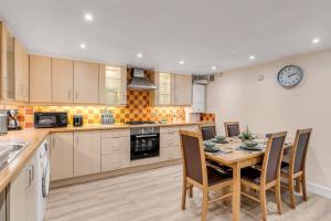 a kitchen with a table and chairs and a clock on the wall at Brewery View Central Close To Restaurants 2 Bed Stylish Apt Lift Unique in Norwich