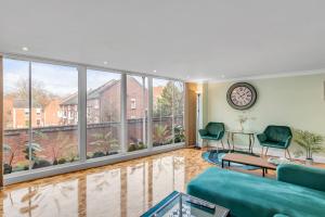 a living room with large windows and a couch at Brewery View Central Close To Restaurants 2 Bed Stylish Apt Lift Unique in Norwich