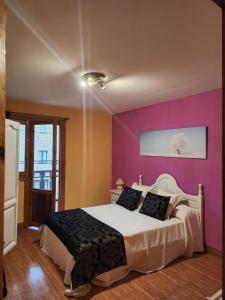 um quarto com uma cama branca e paredes roxas em Vivienda de uso Turístico LARA 