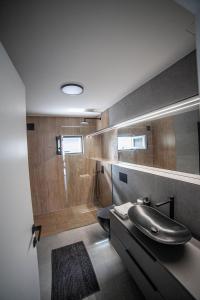 een badkamer met een wastafel en een douche met een bad bij Apartman Teo in Velika Gorica