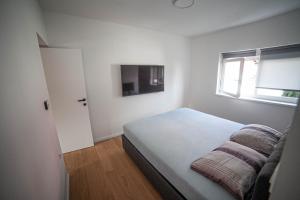 a small bedroom with a bed and a window at Apartman Teo in Velika Gorica