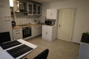 a kitchen with white cabinets and a white refrigerator at Romantisches Main Erlebnis in Gemünden