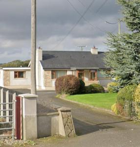ein Haus mit einem Zaun davor in der Unterkunft Drumgauty Cottage in Strabane