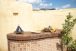 a table with a table cloth on it next to a wall at Riad Arabella in Fez