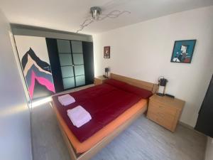 a bedroom with a large red bed in a room at Today Appartement in Chippis