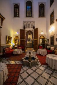 Riad Arabella في فاس: غرفة معيشة مع غرفة كبيرة مع موقد