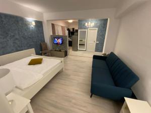 a room with a bed and a couch and a television at TEN APARTAMENT in Eforie Nord