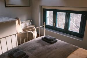 1 dormitorio con 1 cama con 2 toallas en Can Mateu, bonito apartamento céntrico con parking, en Camprodon