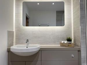 a bathroom with a sink and a mirror at No29, Luxury Apartment near Bicester Village in Bicester
