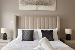 a bedroom with a large white bed with two lamps at No29, Luxury Apartment near Bicester Village in Bicester
