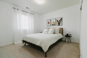 um quarto branco com uma cama com almofadas brancas em Spacious 3 BR House w hot tub in SE Portland, Sleeps 6 near popular attractions em Wood Village