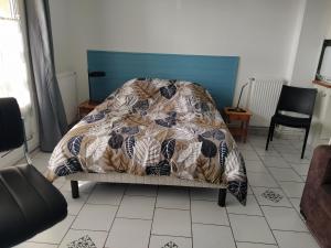 ein Bett mit einer Decke auf dem Zimmer in der Unterkunft Abri Côtier-3 étoiles-vue imprenable sur port de plaisance in Fécamp