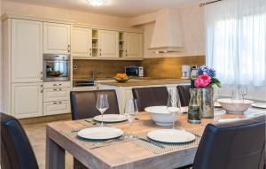 a kitchen with a wooden table with chairs and a dining room at Beautiful Home In Turcic With Wifi in Vantačići