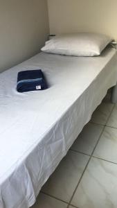 a white bed with a blue bag sitting on it at Hostel Gomes in Sao Paulo