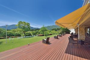 a patio area with chairs, tables and umbrellas at Hakone Lake Hotel in Hakone