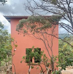 a red building with a window on the side of it at Chales Estrela Veadeiros in Alto Paraíso de Goiás +19 photos