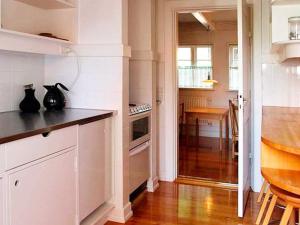 a kitchen with white cabinets and a table and a counter top at 2 person holiday home in Bogense-By Traum in Bogense