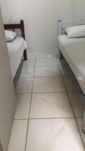 a white tiled floor in a room with two beds at Hostel Gomes in Sao Paulo