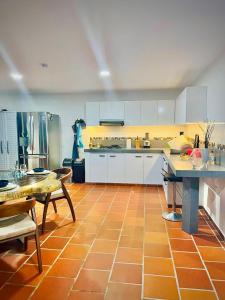 cocina con armarios blancos y suelo de baldosa naranja en Ruitoque Maravillosa Vista 1,5 Km Parque Parapente, en Floridablanca