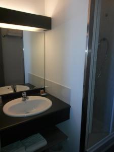 a bathroom with a sink and a mirror at The Originals Boutique, Hôtel Alizé, Évian-les-Bains in Évian-les-Bains +37 photos
