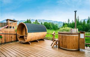 una terrazza in legno con vasca idromassaggio e vasca idromassaggio in legno di Gorgeous Apartment In Koscielisko With Wifi a Kościelisko
