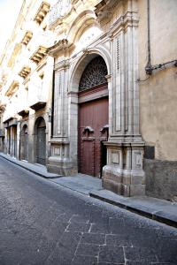 een groot gebouw met een bruine deur op een straat bij Palazzo Aprile in Caltagirone