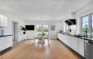 a kitchen with white cabinets and a table and chairs at Nice Home In Grindsted With House A Panoramic View in Grindsted