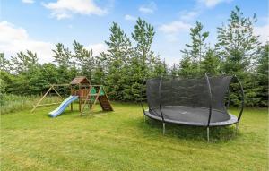 two childrens play equipment in a yard with a playground at Nice Home In Grindsted With House A Panoramic View in Grindsted