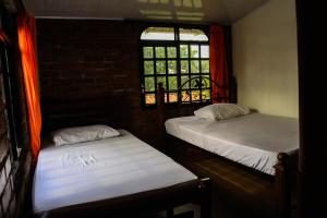 2 camas en una habitación con ventana en Villa el Remanso, en Montenegro
