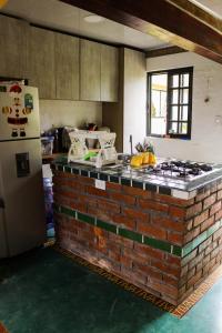 cocina con encimera de ladrillo y nevera en Villa el Remanso, en Montenegro