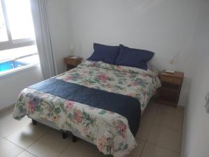 1 dormitorio con 1 cama con edredón de flores en Tapuy Porá en Corrientes