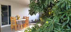 a table and chairs on a porch with plants at Fare Onavai in Punaauia