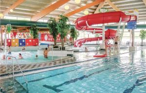 una piscina con scivolo e persone in acqua di Nice Home In Vlagtwedde With Wifi a Vlagtwedde