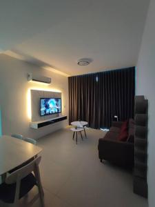 un soggiorno con divano e TV di Kuching 3rd Mile Yarra Park Apartment a Kuching