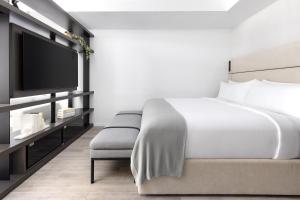 a bedroom with a bed and a flat screen tv at The Elser Hotel Miami - An All-Suite Hotel in Miami