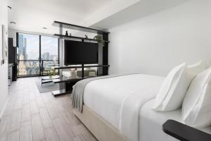 a hotel room with a bed and a flat screen tv at The Elser Hotel Miami - An All-Suite Hotel in Miami +99 photos