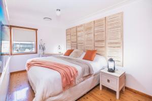 1 dormitorio con 1 cama grande y cabecero de madera en Cool Change Accommodation And Venue Hire, en Nelson Bay