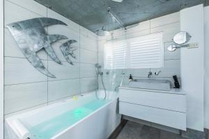 baño con bañera y pintura de ballenas en la pared en Cool Change Accommodation And Venue Hire, en Nelson Bay