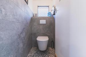 a bathroom with a toilet in a small room at Cool Change Accommodation And Venue Hire in Nelson Bay