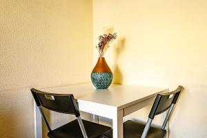 eine Vase auf einem Tisch mit zwei Stühlen in der Unterkunft Porto Central Home in Porto