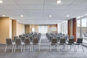 una sala de conferencias con sillas y una pantalla blanca en Adina Apartment Hotel Wollongong en Wollongong