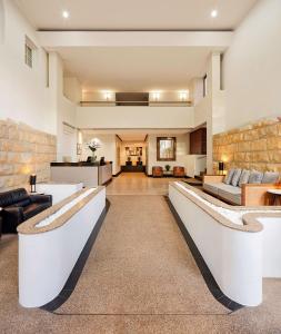 a large living room with a stone wall at Rendezvous Hotel Sydney The Rocks in Sydney